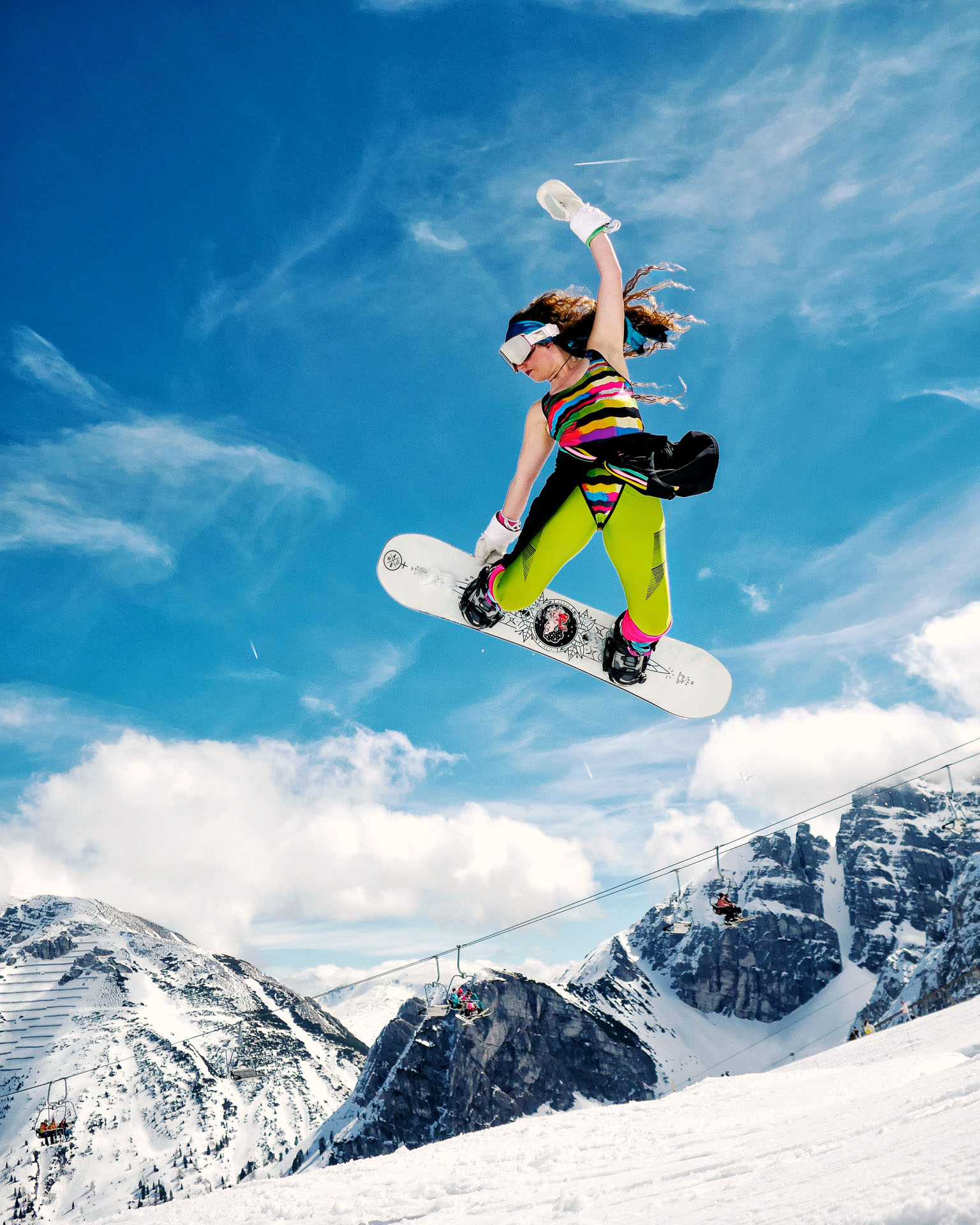 Eine Snowboarderin in ausgefallenem Outfit fährt im Funpark.