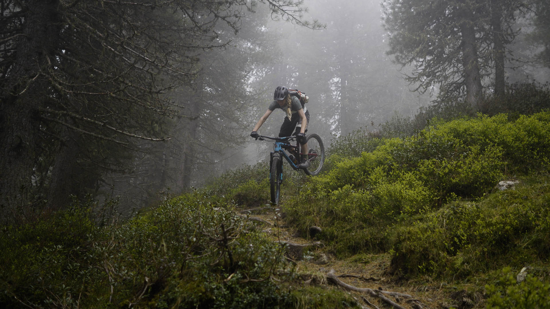The mountain bike woman Maria riding her enduro bike on a scenic, technical trail.